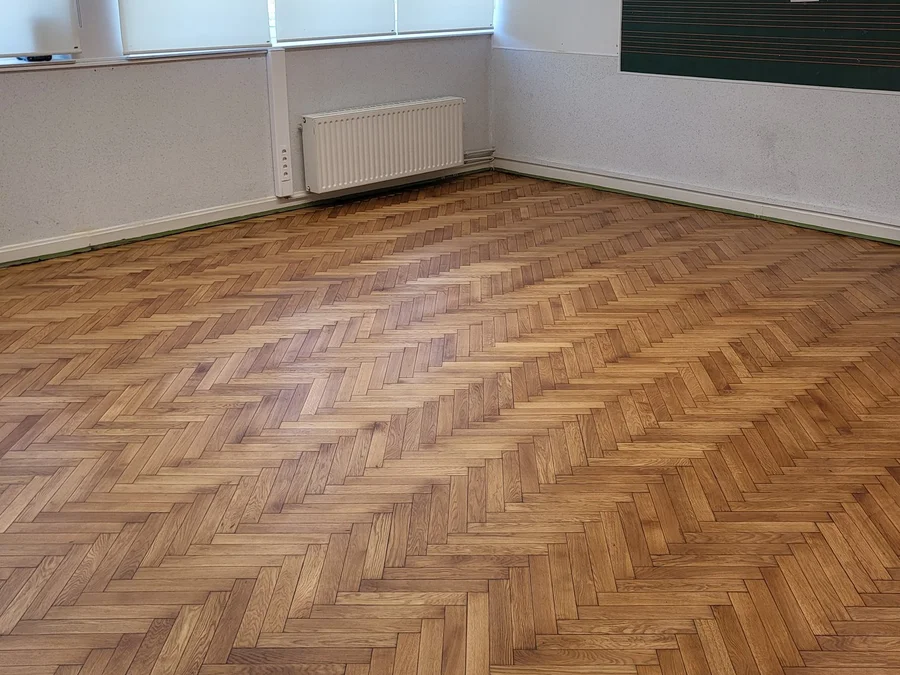 Rénovation d'un parquet à bâtons rompus dans une salle de classe