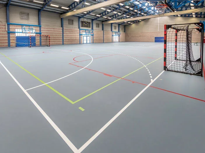 Sol de hall de sport avec marquages de terrains blancs, jaunes et rouges