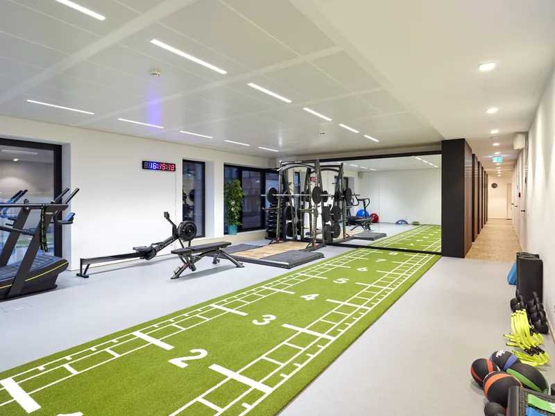 Piste de gazon synthétique verte numérotée dans une salle de fitness