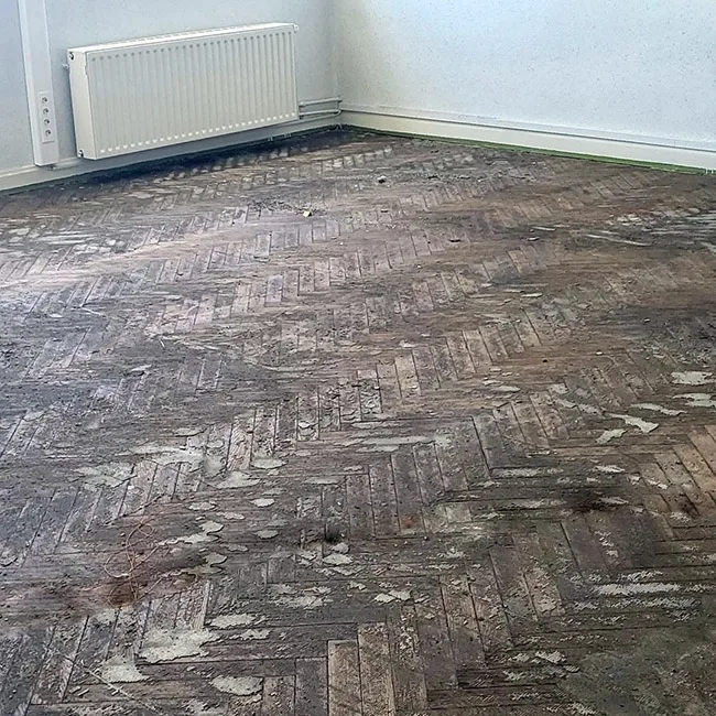 Parquet abîmé avant rénovation, dans une pièce à vivre au Luxembourg